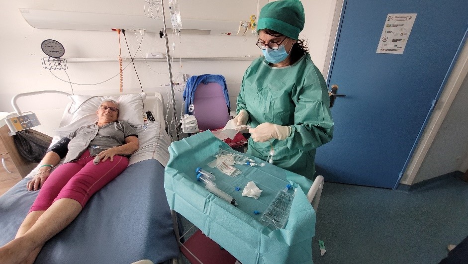 Patiente allongée sur son lit d'hôpital avec professionnel de santé debout