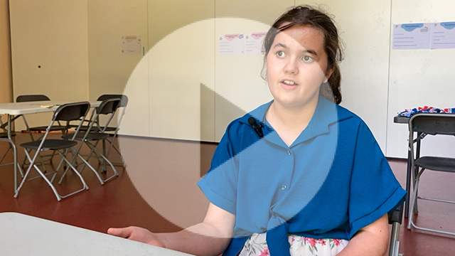 Une salle de réunion, une enfant de face assise à une table