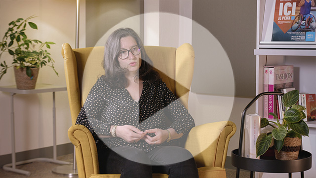 Elise en noir, assise sur un fauteuil jaune moutarde