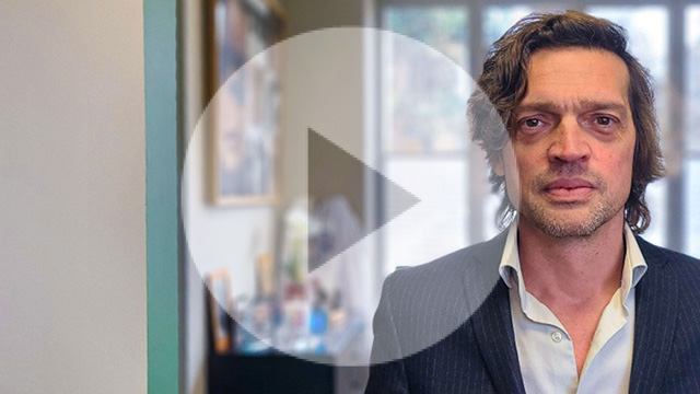 Pr Alexandre Denoyer debout chemise blanche et veste de costume noire et rayée blanche