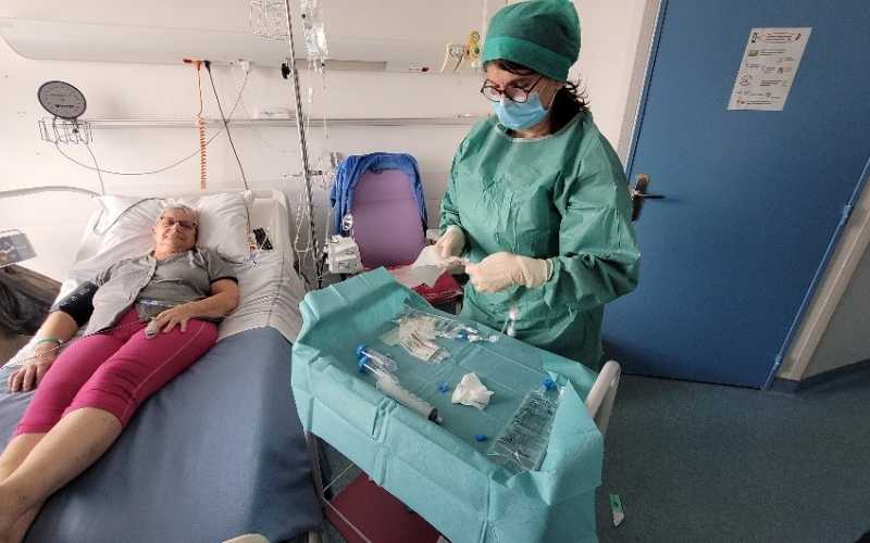 Patiente allongée sur son lit d'hôpital avec professionnel de santé debout