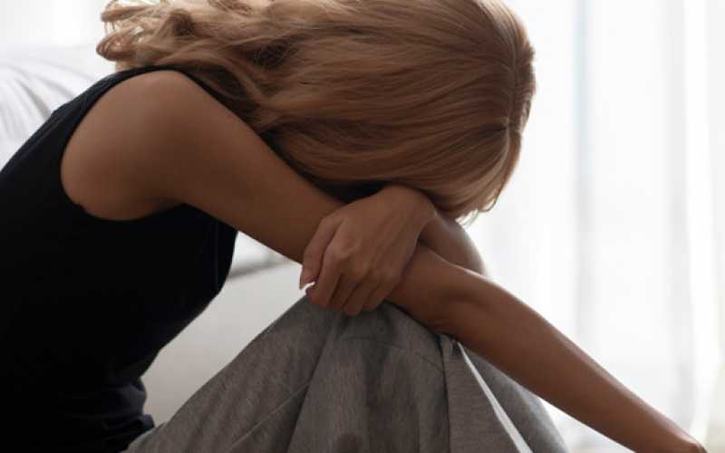 Jeune fille assise qui semble pleurer