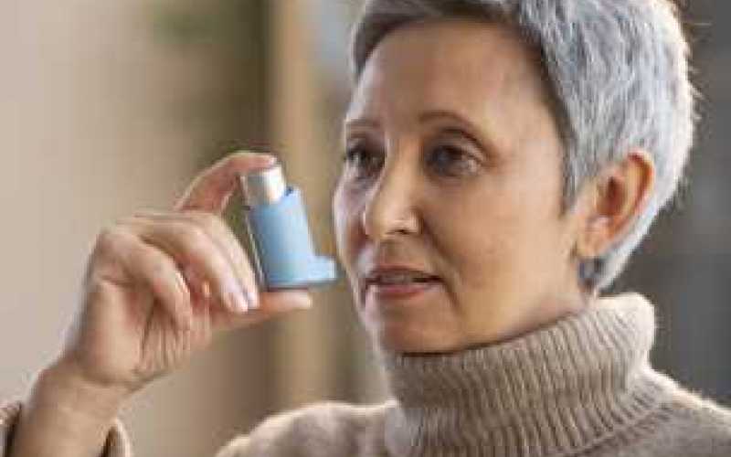 Femme avec inhalateur pour traitement asthme