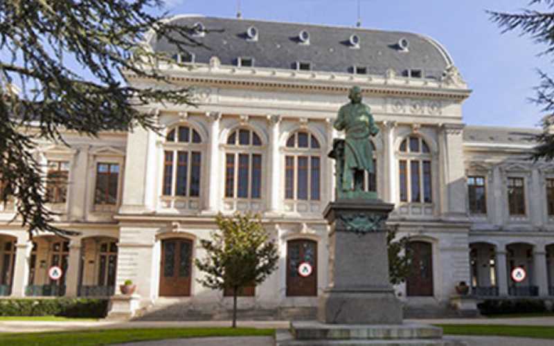 vue extérieure du palais hisrch de Lyon, depuis la cour. au premier plan, une statue.