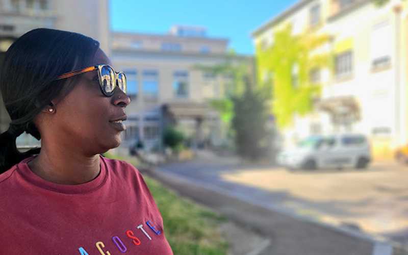 Femme portant des lunettes de soleil de profil avec cheveux attachés et sweat couleur lie de vin