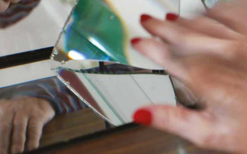 Reflets d'un miroir avec une main avec vernis rouge et une autre main