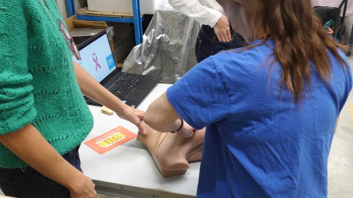 Une femme s'essaie à la palpation sur le mannequin de simulation