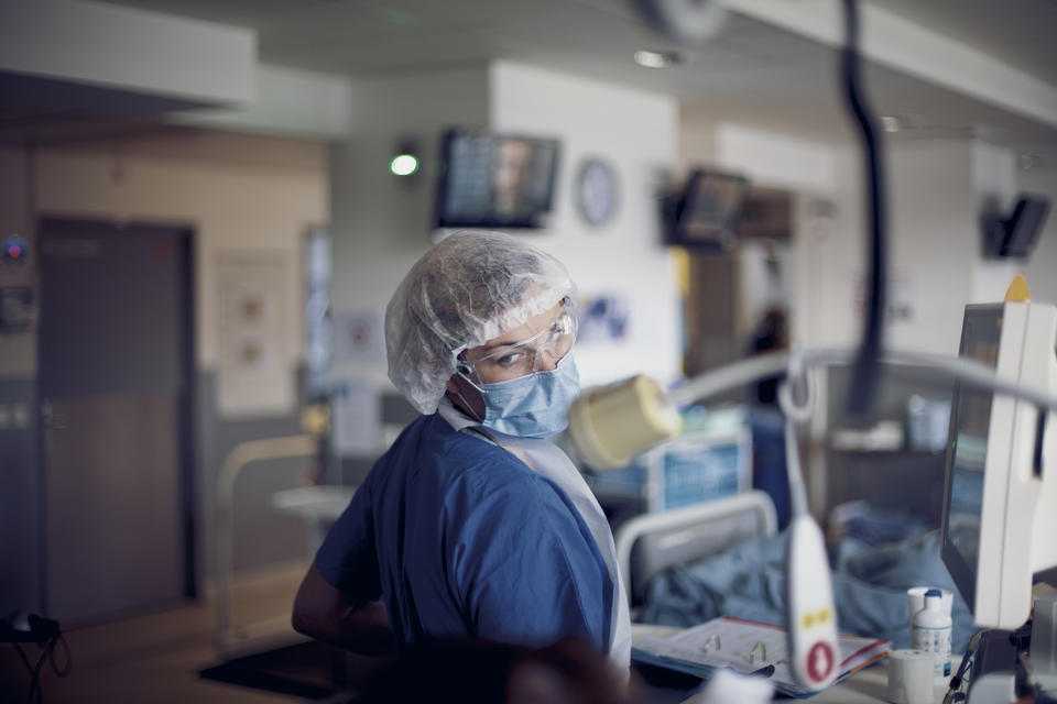 une infirmière avec un masque regarde les équipements de dialyse