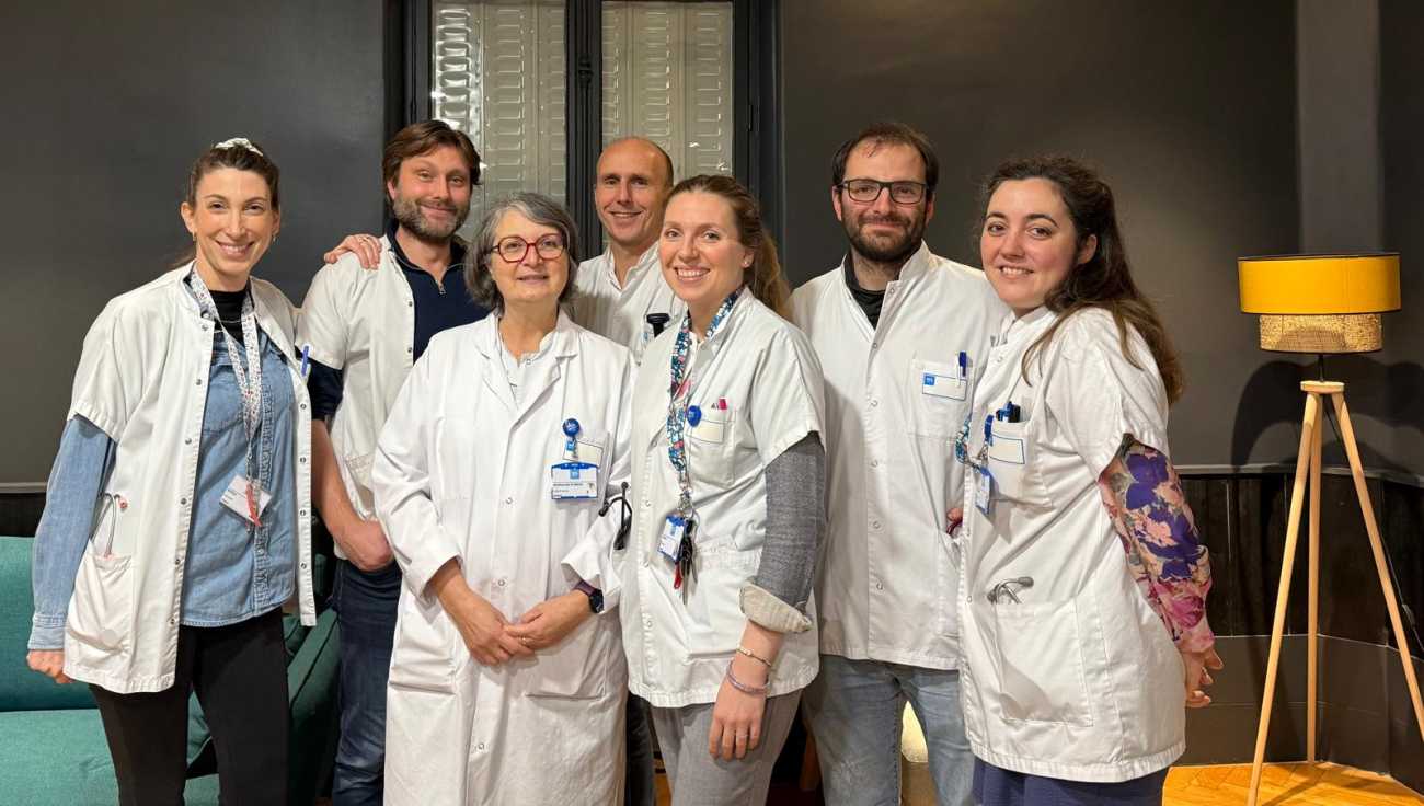 Sept médecins, des hommes et des femmes, sourient et posent en blouse blanche