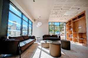 un salon avec un canapé sur la gauche et de grandes porte-fenetres.