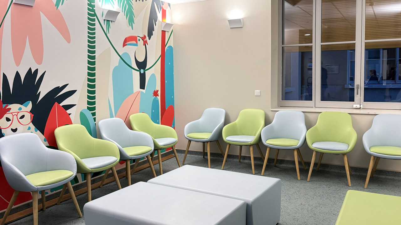 Intérieur, chaises colorées adossées au mur, fresque avec des animaux de la jungle