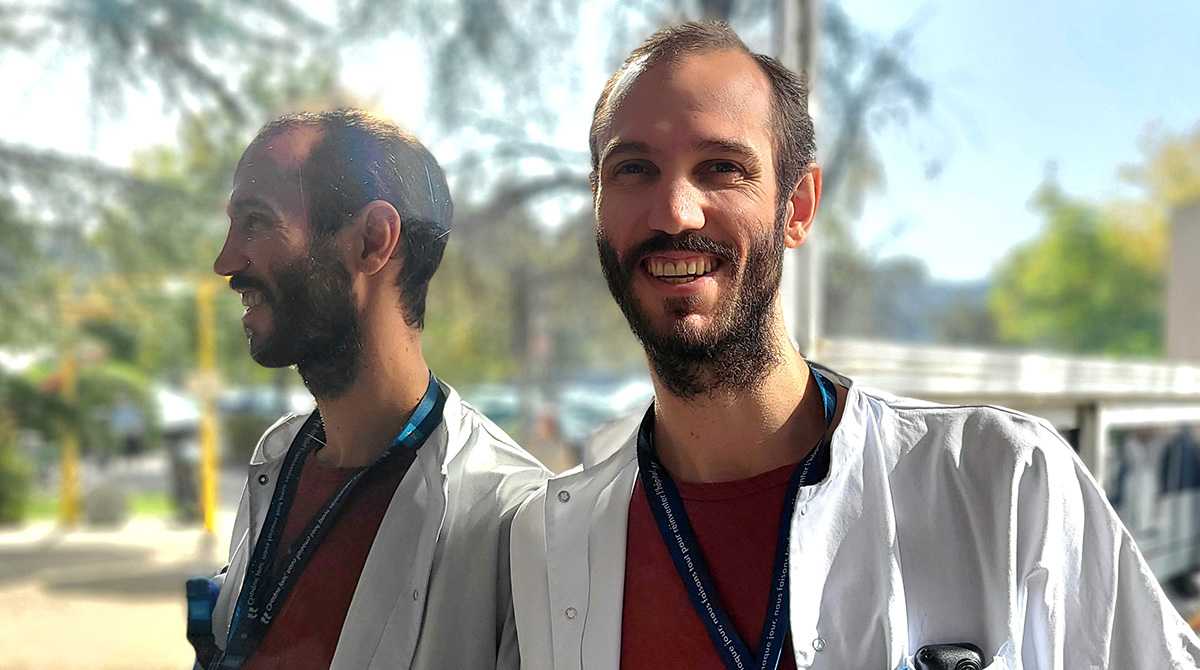 Baptiste Balança qui sourit avec son reflet sur une vitre à l'arrière