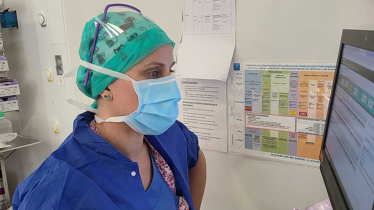 Charlotte devant son écran vérifie la check-list opératoire de l’intervention chirurgicale.