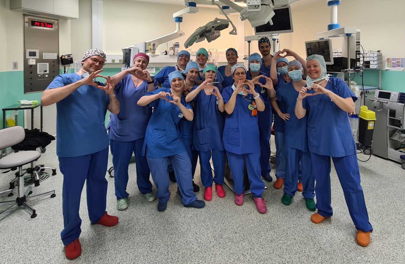 Les équipes qui ont réalisé la 500e greffe hépatique pédiatrique à l'HFME, elles posent dans la salle d'opération en blouses bleues et font des coeurs avec les mains.