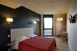 chambre avec un lit deux places, une couverture rouge