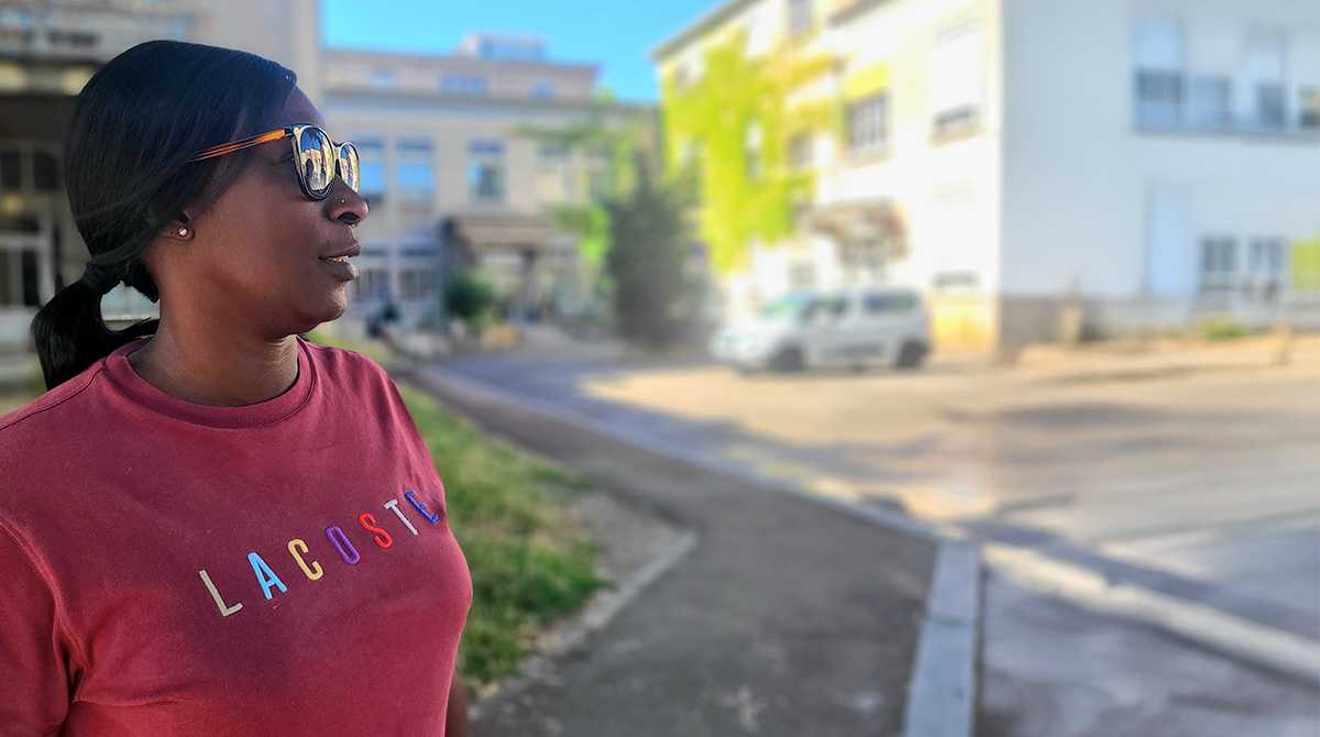 Femme portant des lunettes de soleil de profil avec cheveux attachés et sweat couleur lie de vin