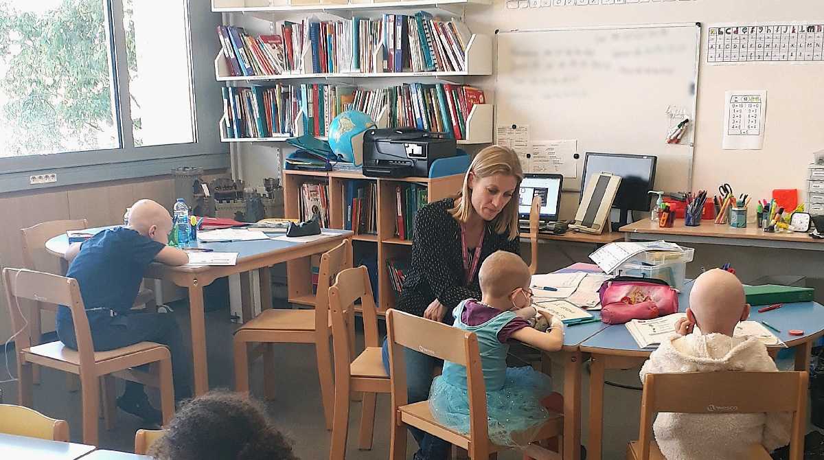 Salle de classe avec enfants de dos assis sur des chaises