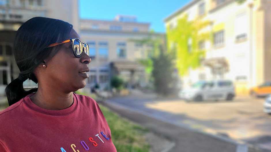 Femme portant des lunettes de soleil de profil avec cheveux attachés et sweat couleur lie de vin